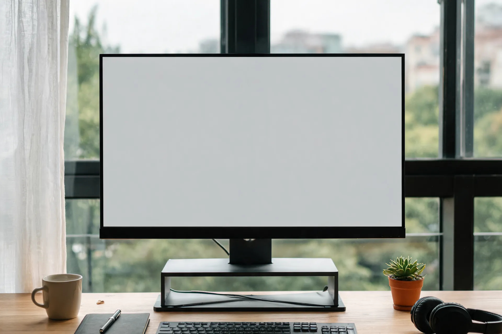 Schreibtisch mit Monitor am Fenster, darauf die Websites unserer Kunden